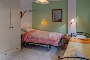 Ein barrierefreies Schlafzimmer mit Pflegebett im griechischen Freizeitheim Apollon für Gruppenreisen.