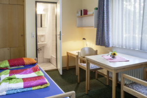 Ein Schlafzimmer mit eigenem Bad im Freizeithaus Heliand für Kinder und Jugendfreizeiten in Deutschland.
