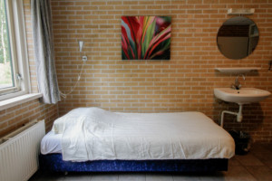 Ein Schlafzimmer mit Waschbecken im niederländischen Gruppenhaus Eikenhorst.